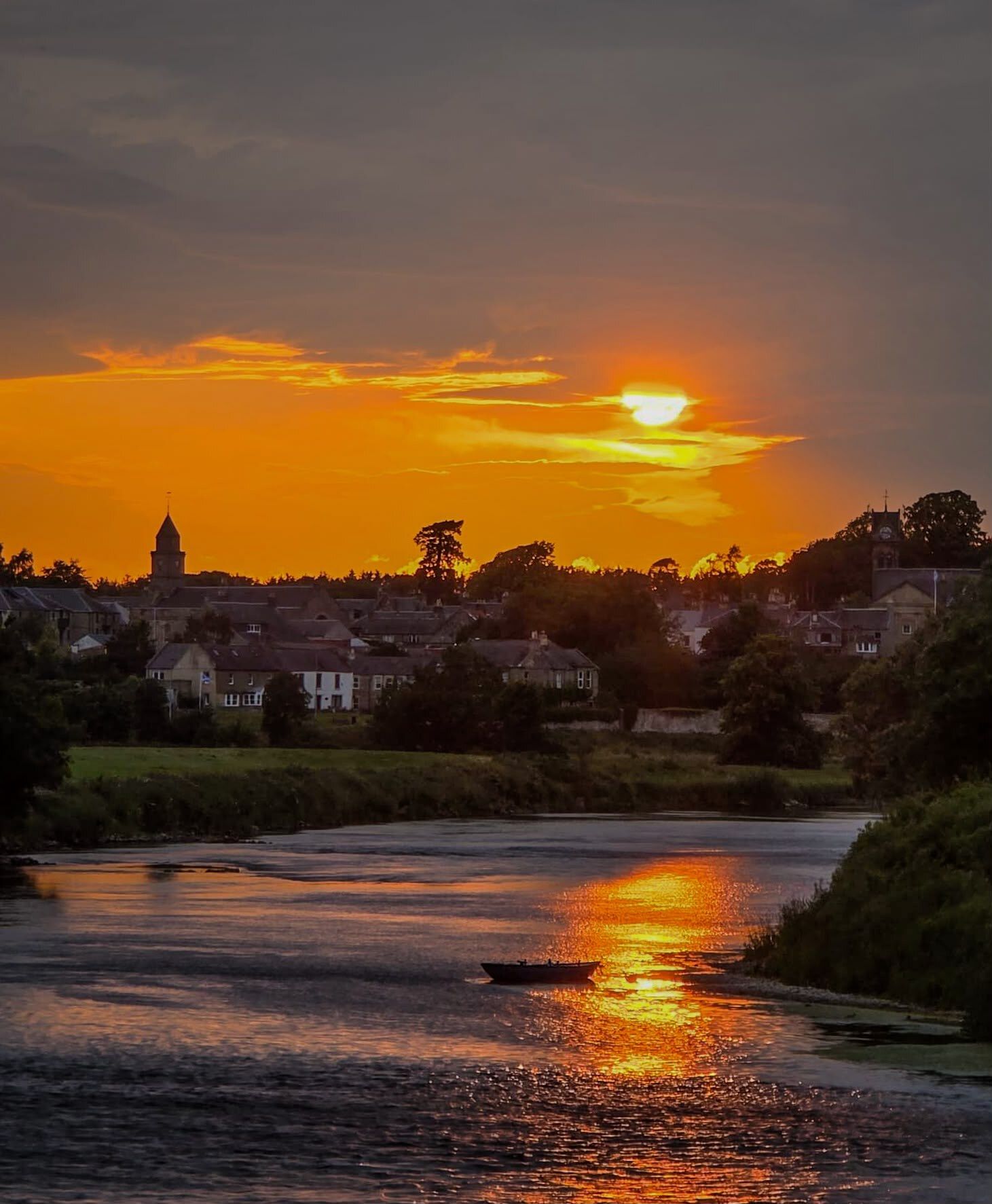 Sunset over Coldstream with a rowing boat on the river below